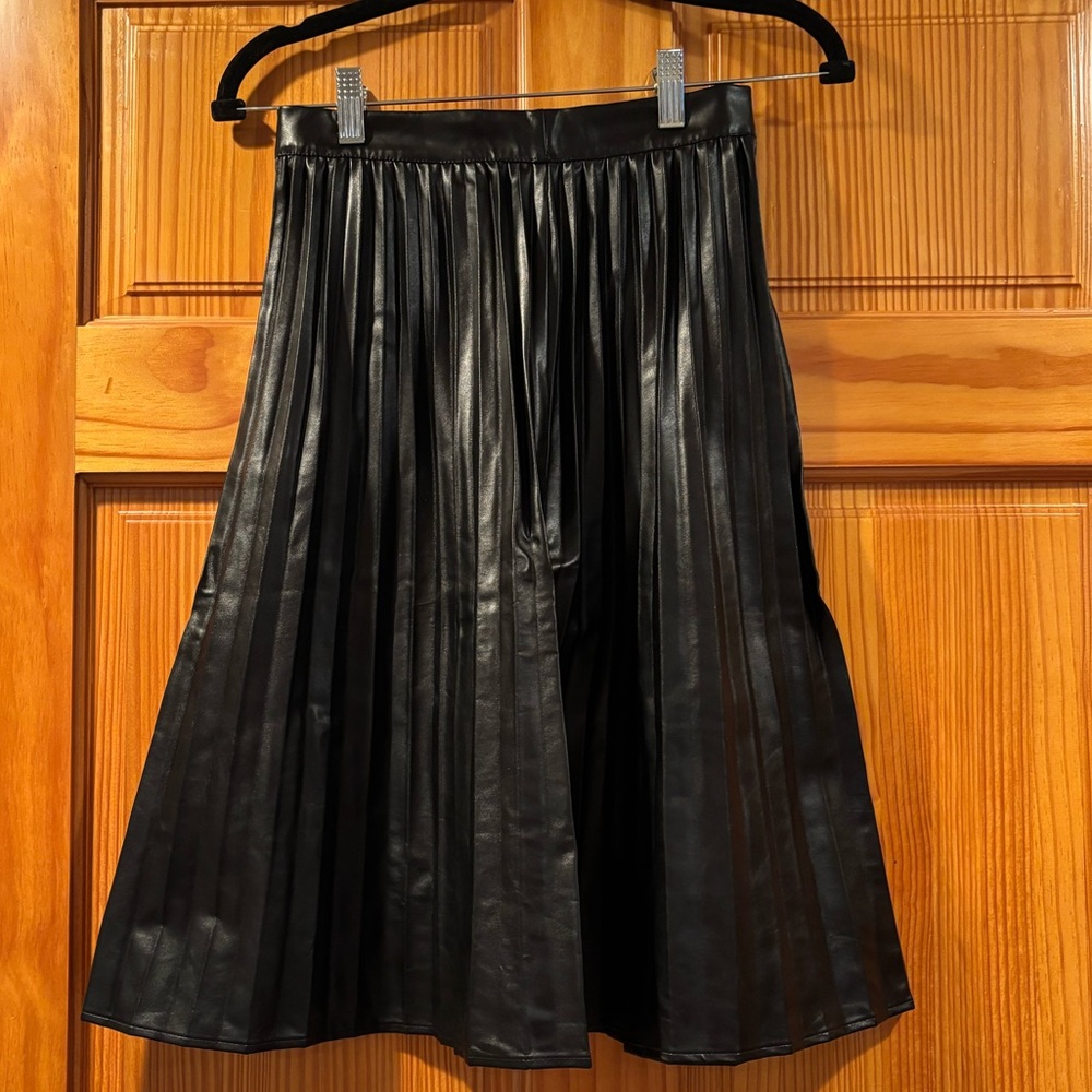 Monteau black pleated “leather” (polyester) skirt, knee length